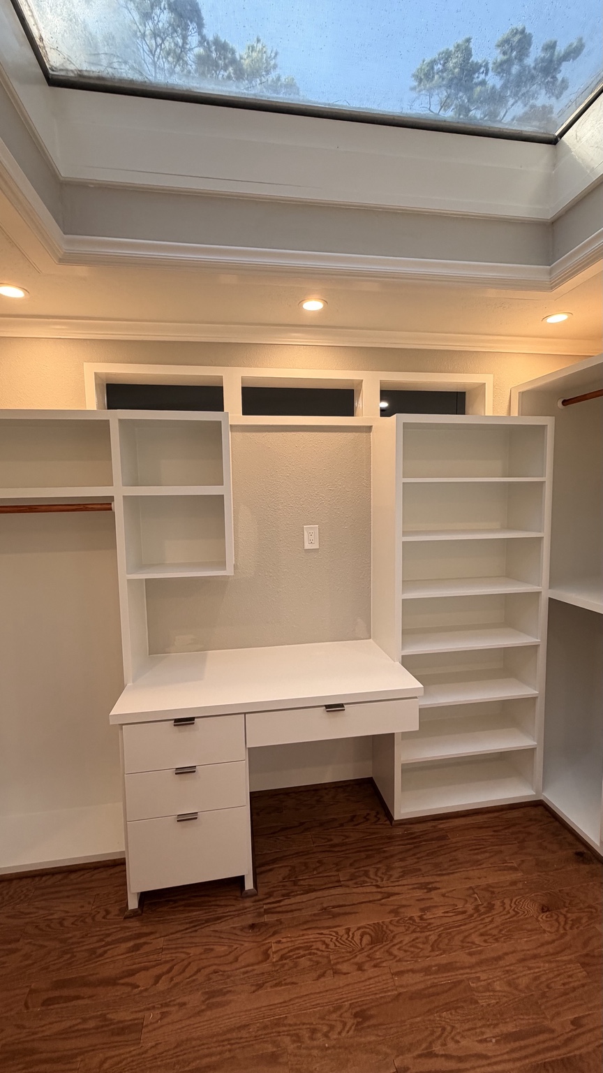Closet shelving with stained wood hanging rods