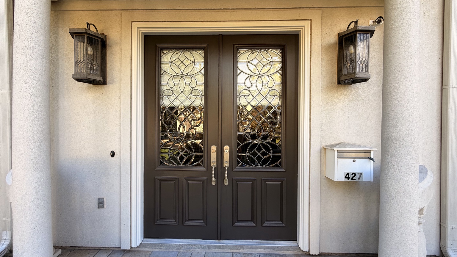 Detailed view of finished charcoal double entry doors with decorative glass